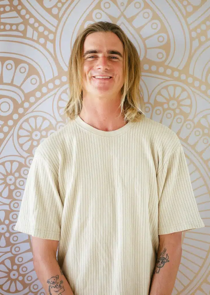 David Wilson smiling in front of a patterned studio wall
