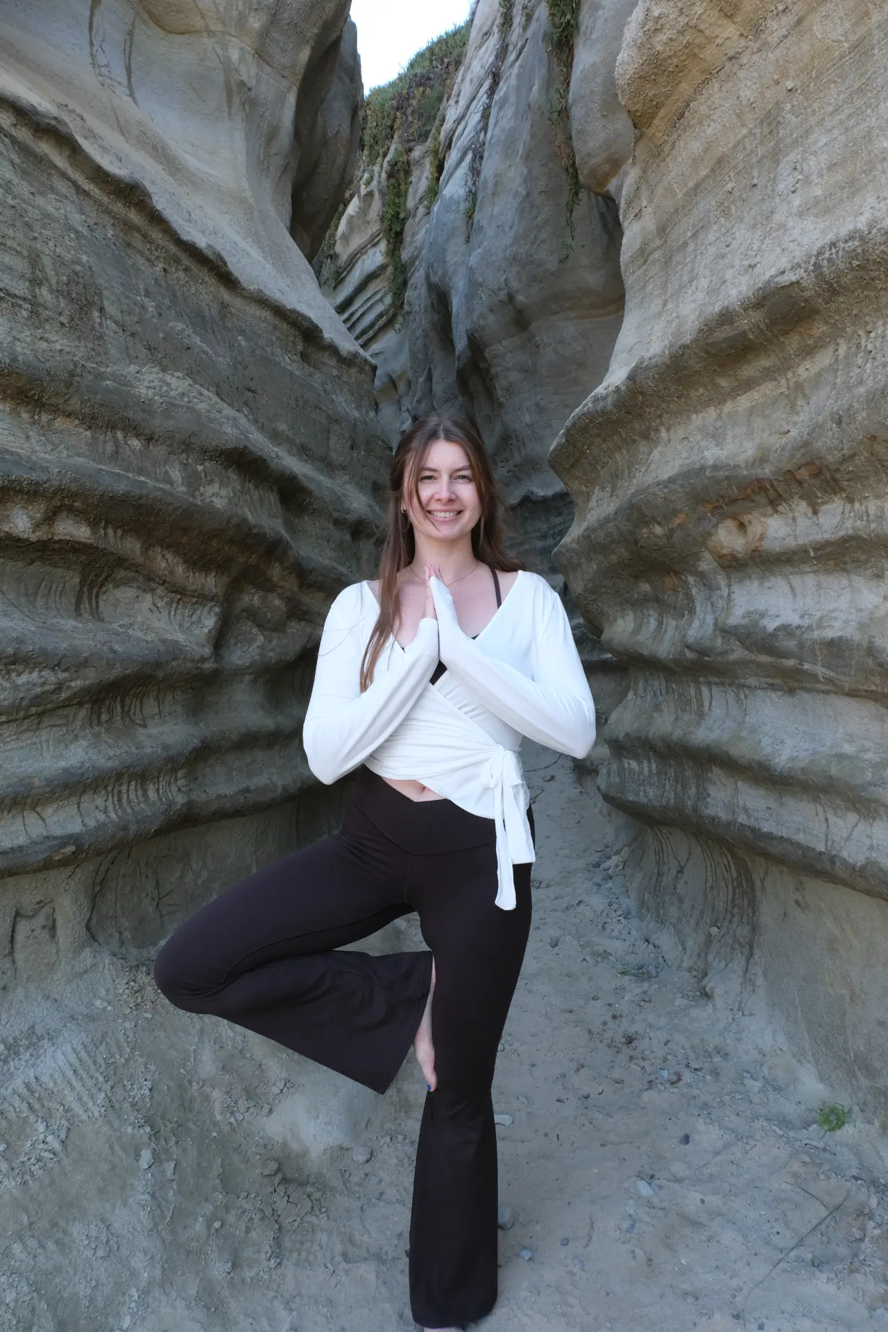 Hannah Milner in a yoga tree pose inside a slot canyon