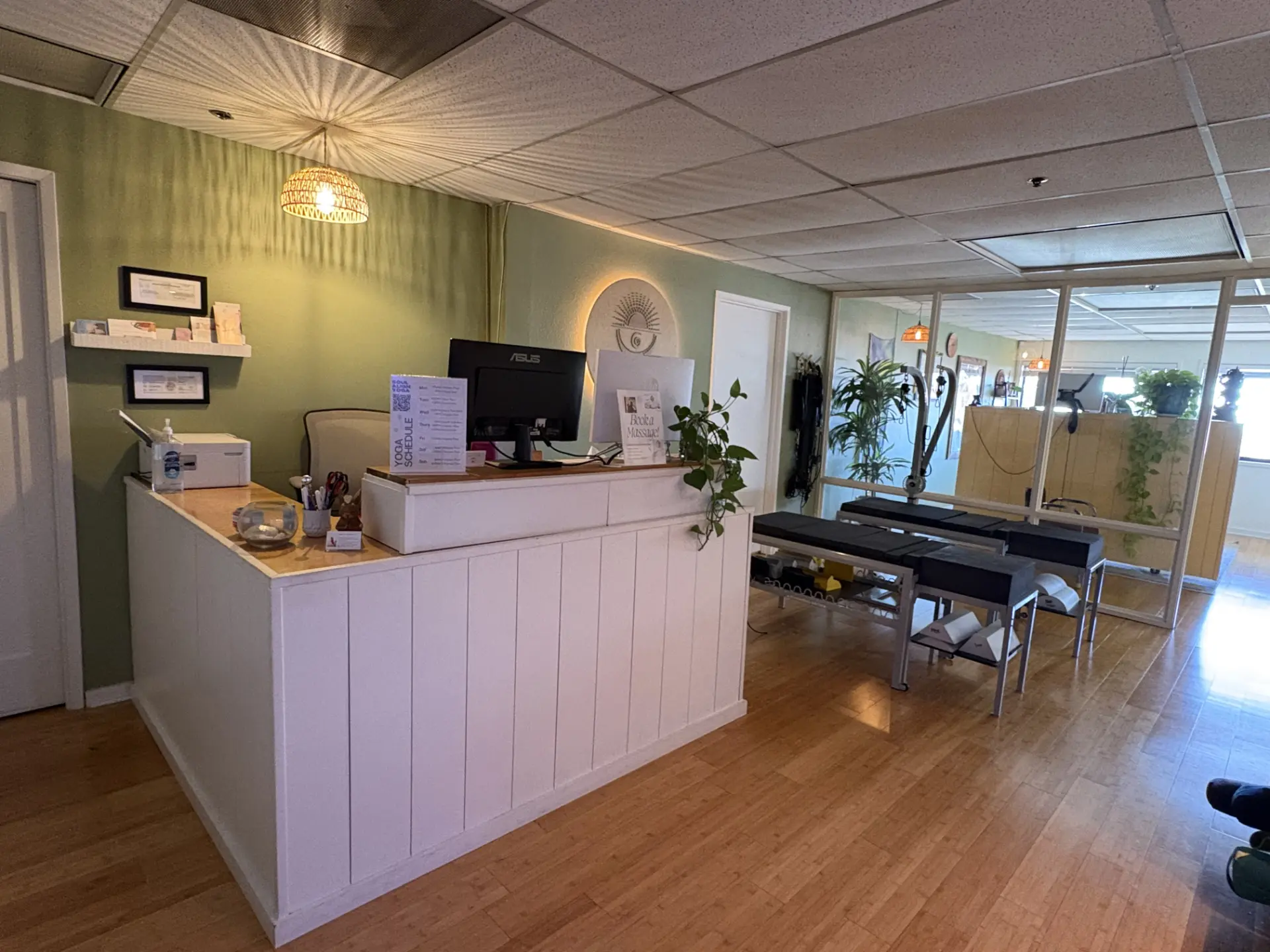 The Soul Align front desk with a backlit logo on a sage green wall